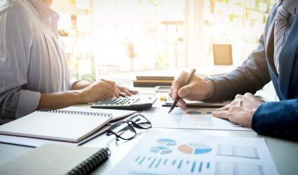 business man financial inspector and secretary making report, ca business man financial inspector and secretary making report, calculating or checking balance. Internal Revenue Service inspector checking document. Audit concept
